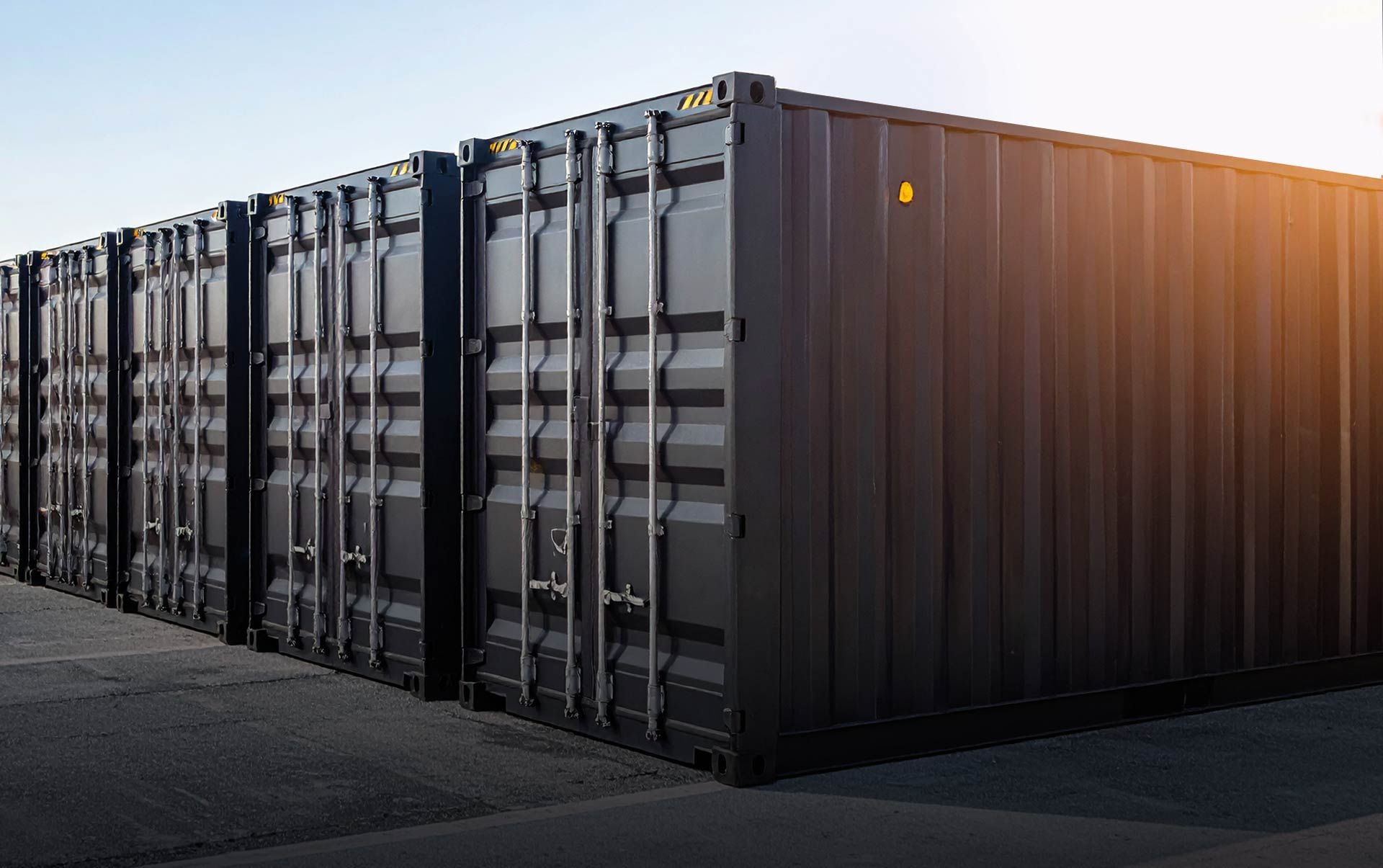 Eine Reihe schwarzer Lagercontainer im Sonnenschein